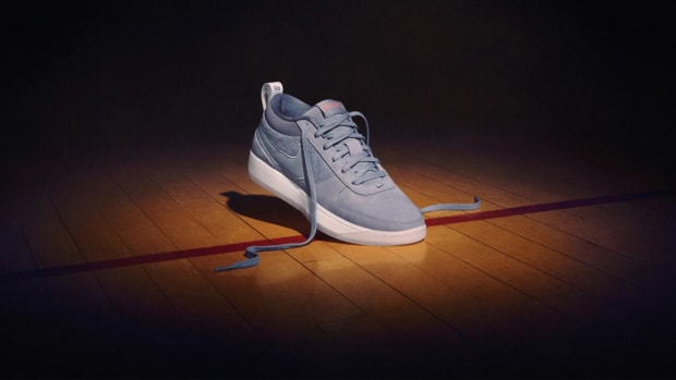 Devin Booker's grey Nike sneakers on a basketball court.